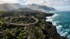 Vue panoramique de la Route des Laves traversant les coulées volcaniques solidifiées entre le noir de la lave et le bleu de l'océan Indien