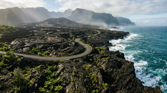 Vue panoramique de la Route des Laves traversant les coulées volcaniques solidifiées entre le noir de la lave et le bleu de l'océan Indien