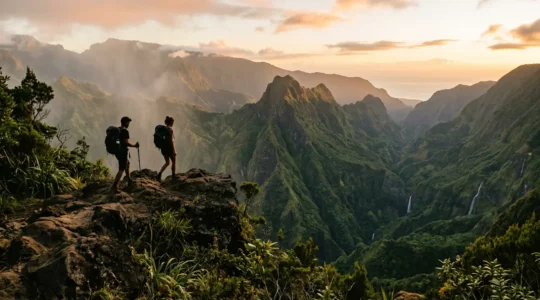 Randonneurs contemplant un cirque montagneux tropical de La Réunion au coucher du soleil avec sac à dos et économies