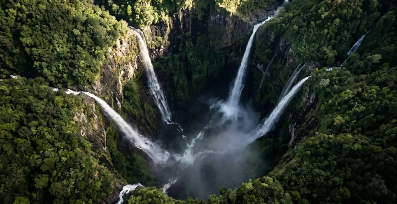 Vue aérienne du gouffre du Trou de Fer avec ses cascades monumentales disparaissant dans la brume