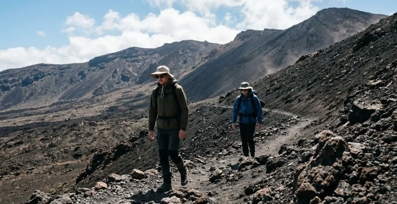 Randonneurs équipés de vêtements multicouches sur les pentes volcaniques exposées