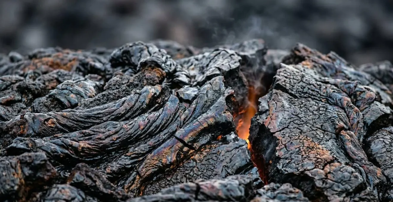 Détail macro de la croûte vitrifiée d'une coulée de lave montrant les fissures et textures de refroidissement